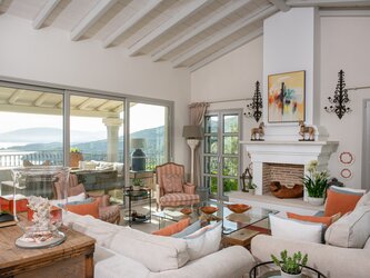 Large sitting room with fireplace opening onto front and back terraces