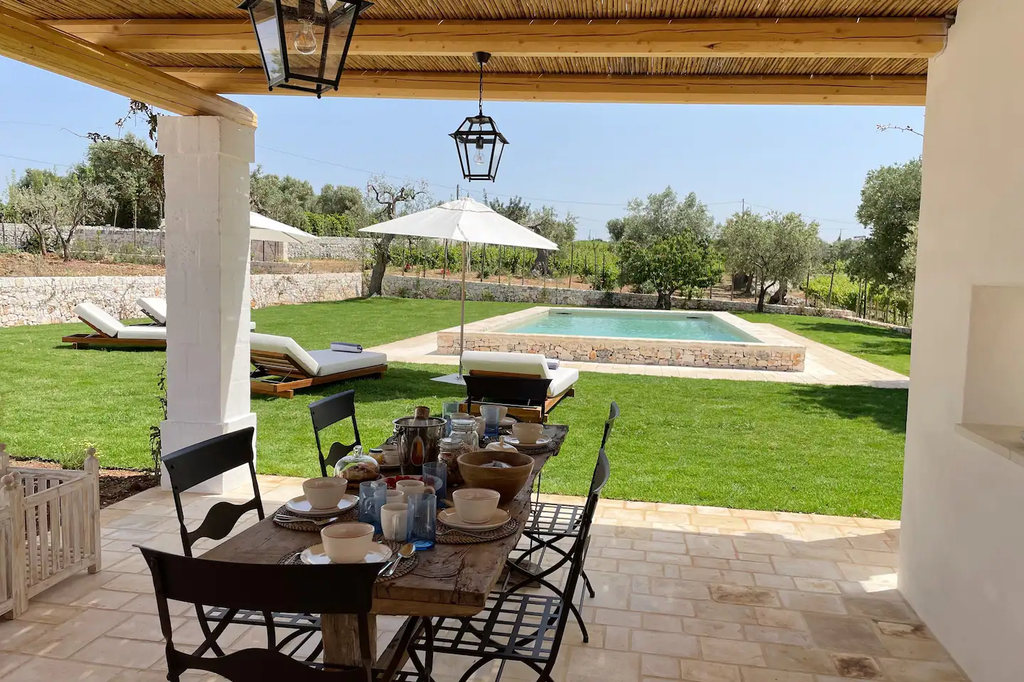 Outdoor dining pergola overlooking the beautiful garden and pool area. 