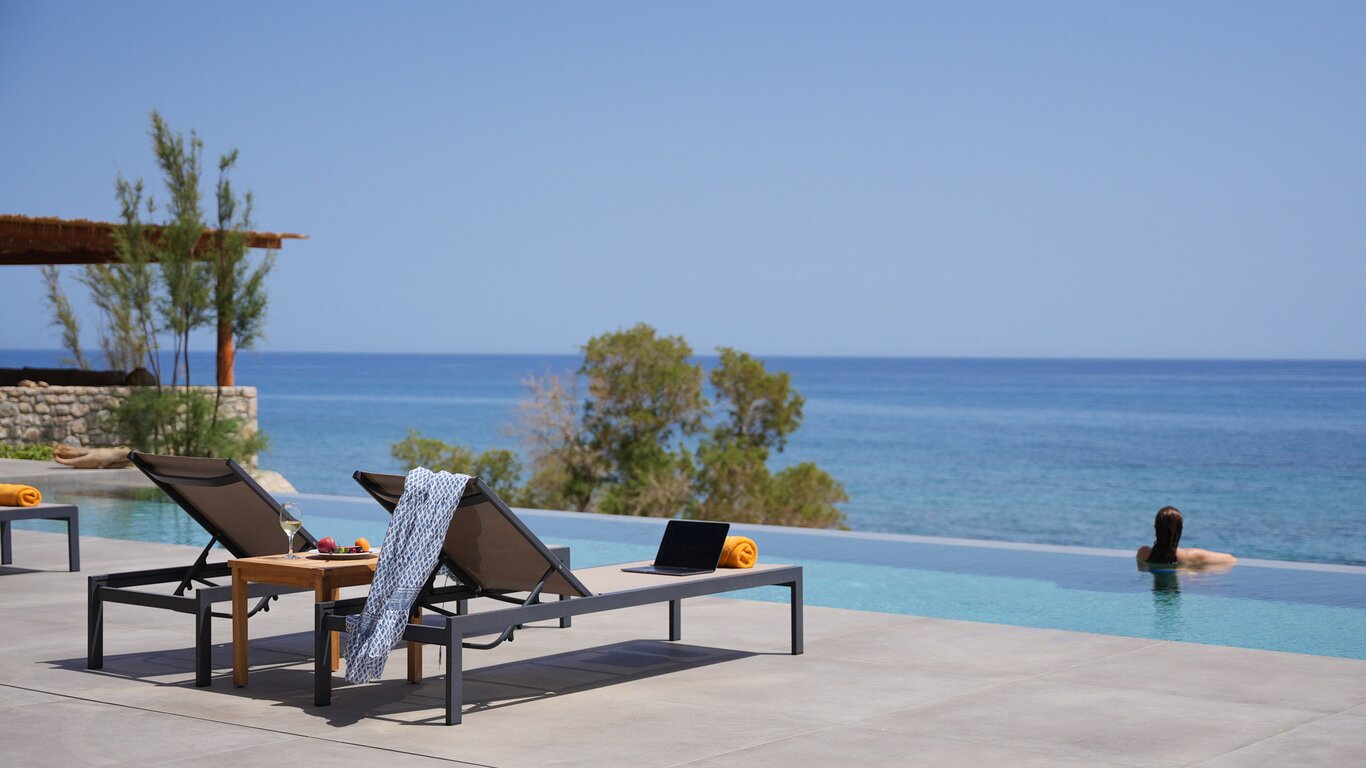 Woman relaxing by pool at Beach House Amira